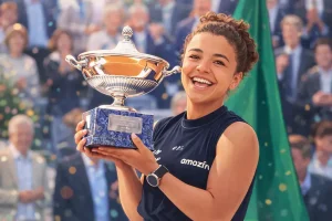 Jasmine Paolini smiles while holding the winner's trophy at the 2025 Rome tennis tournament, celebrating her biggest career title.